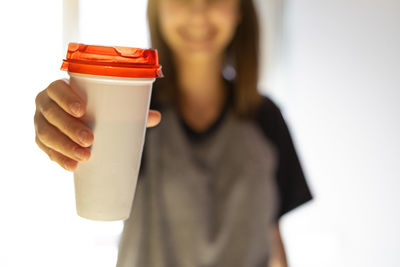 Midsection of woman holding coffee cup