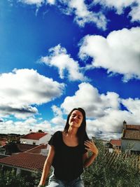 Young woman against mountains against cloudy blue sky