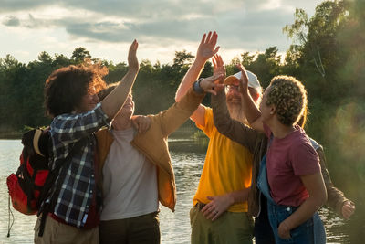 Rear view of friends with arms raised standing on field