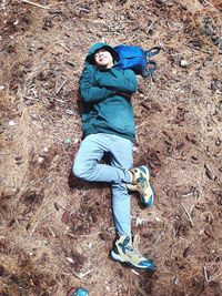 High angle view of young man lying on field