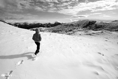 Full length of man walking on snow covered mountain