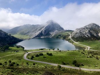 Scenic view of lake by mountains against sky