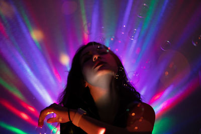 Close-up of woman in illuminated nightclub