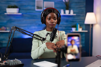 Podcaster gesturing while doing live streaming in studio