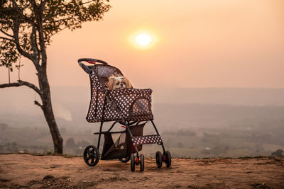 Bicycles on land against sky during sunset