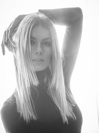 Close-up portrait of young woman against white background