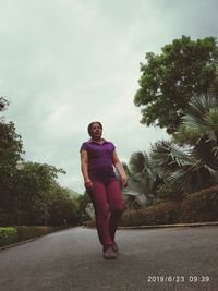 Full length of man standing on road against sky