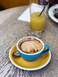 Close-up of coffee cup with juice on wooden table