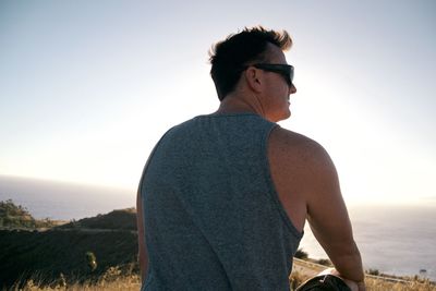 Rear view of man on beach against clear sky