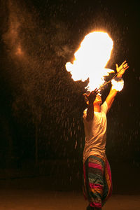 Low angle view of man holding lit candle