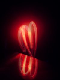 Close-up of illuminated red light against black background