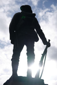 Low angle view of silhouette man standing against sky