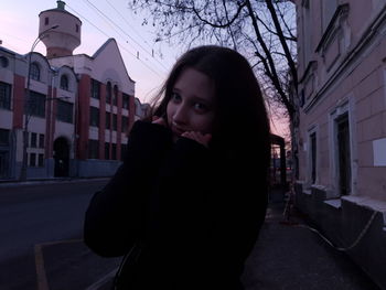 Portrait of woman standing on street in city