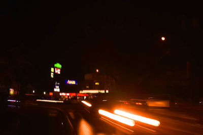 Illuminated cars on road in city at night