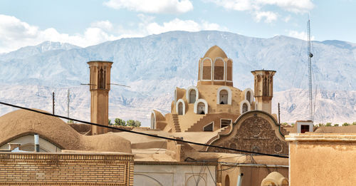 Panoramic view of buildings against cloudy sky