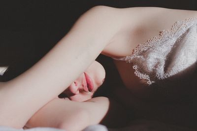 Close-up of beautiful woman lying on bed in darkroom