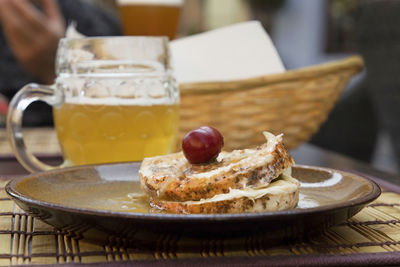 Close-up of pickled hermelin cheese served with beer on table