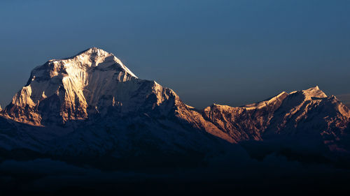 Scenic view of snow covered mountain against clear blue sky