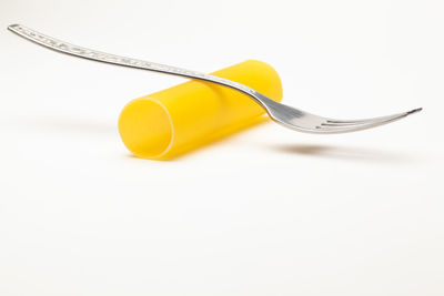 High angle view of yellow container on table against white background