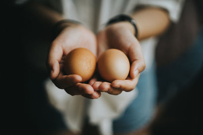 Midsection of woman holding eggs