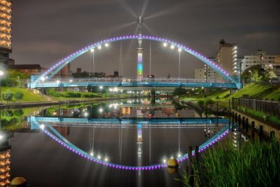 Illuminated bridge over river at night