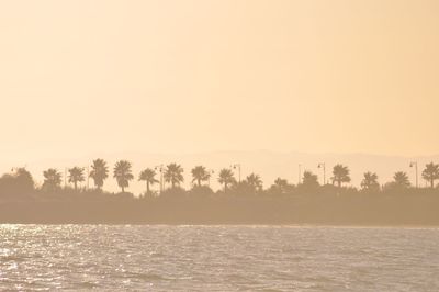 Scenic view of lake against clear sky during sunset