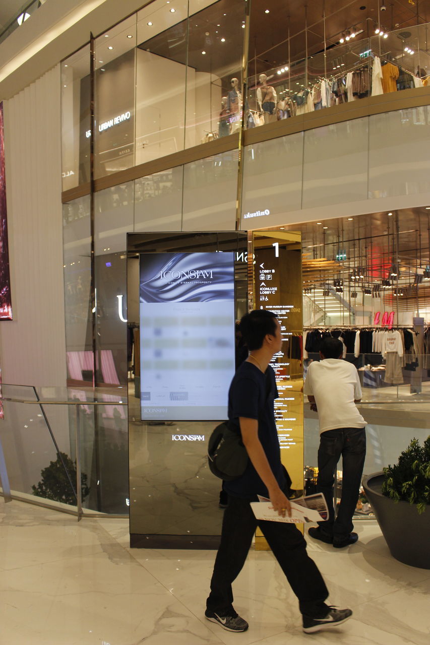 FULL LENGTH OF PEOPLE STANDING IN ILLUMINATED STORE