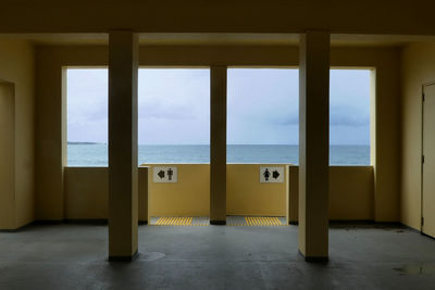 Entrance of building ocean view framed by window 