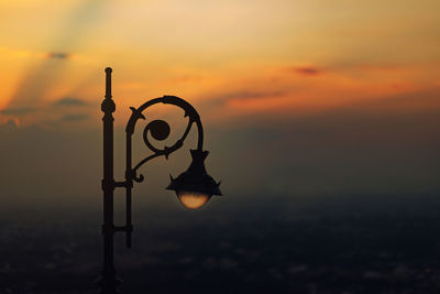 Silhouette crane against sky during sunset