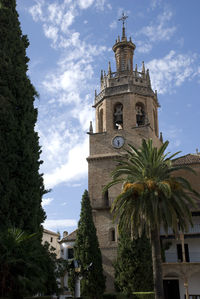 Low angle view of trees and building against sky