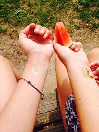 Cropped image of women hands with tattoos