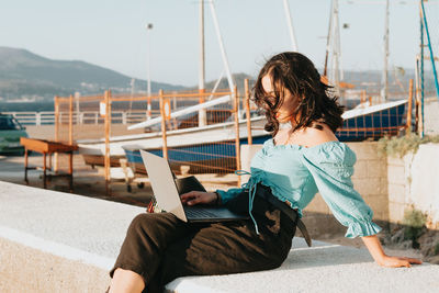 Woman looking at camera while sitting on mobile phone