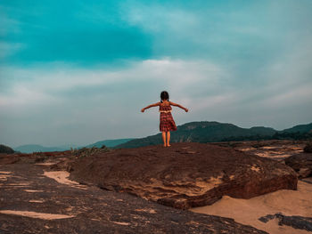 Rear view of man standing on rock