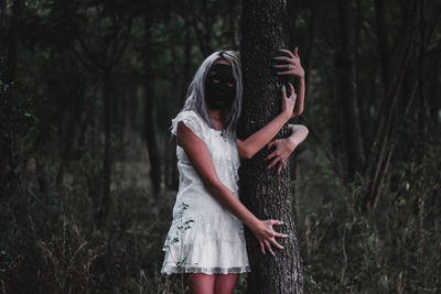 Women hugging trees in forest