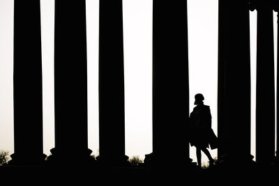 Silhouette man standing against window