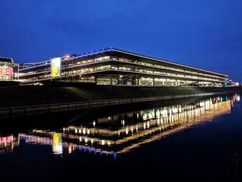 Illuminated bridge over river at night