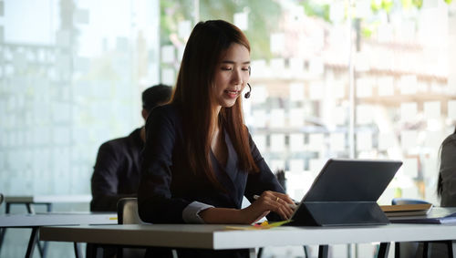 Smiling businesswoman using digital tablet at office