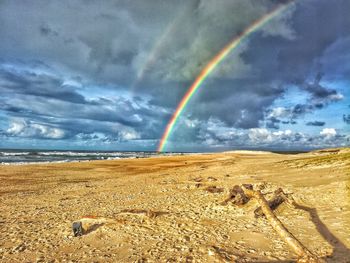 Scenic view of rainbow over sea against sky