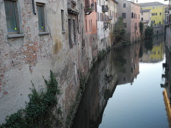 Canal amidst old buildings in city