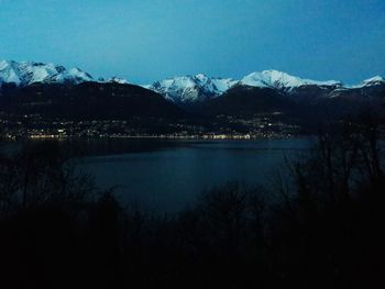 Scenic view of lake by mountains against sky