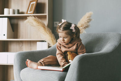 Girl sitting on sofa at home