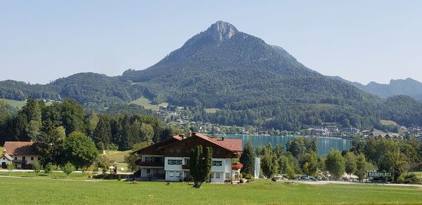 Houses by trees and mountains against sky