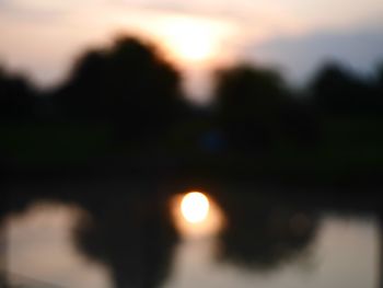 Defocused image of sun against sky during sunset