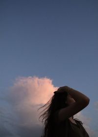 Low angle view of woman against sky during sunset