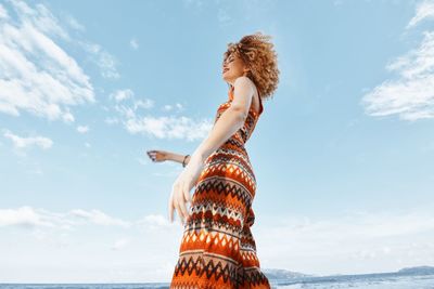 Low angle view of woman standing against sky