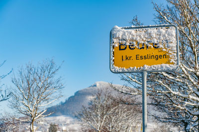 Low angle view of road sign against blue sky