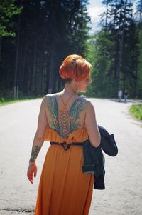 Full length of woman standing by tree