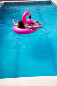 Woman relaxing in inflatable ring on swimming pool