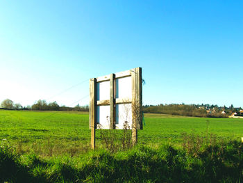 Built structure on field against clear blue sky