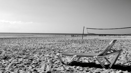 Chairs on beach against sky